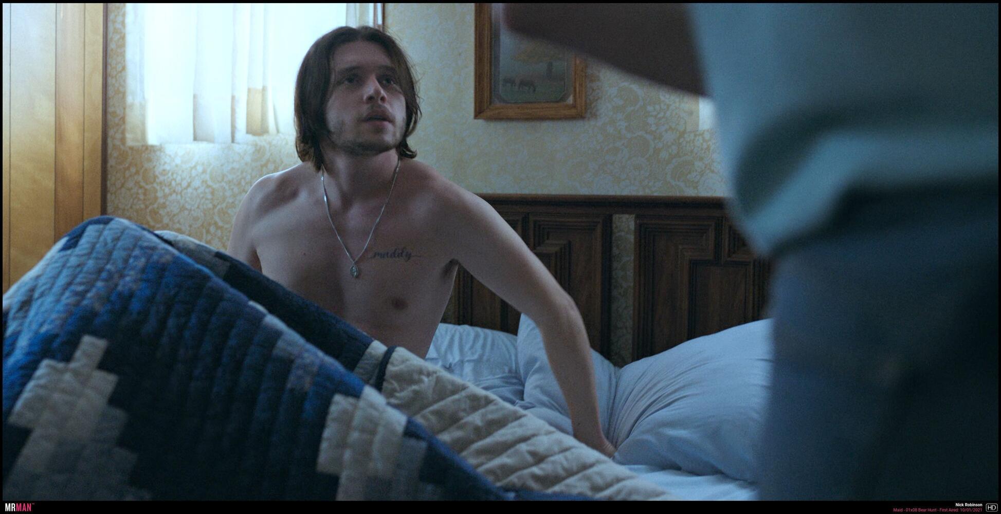 Nick Robinson shirtless in bed with a tattoo