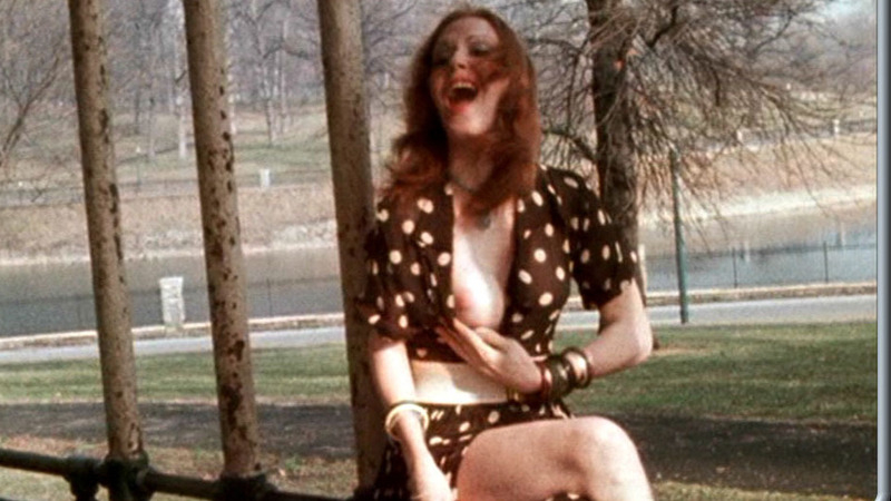 Transsexual in park from Pink Flamingos Naked. Breasts, brown dress, nude. 609557